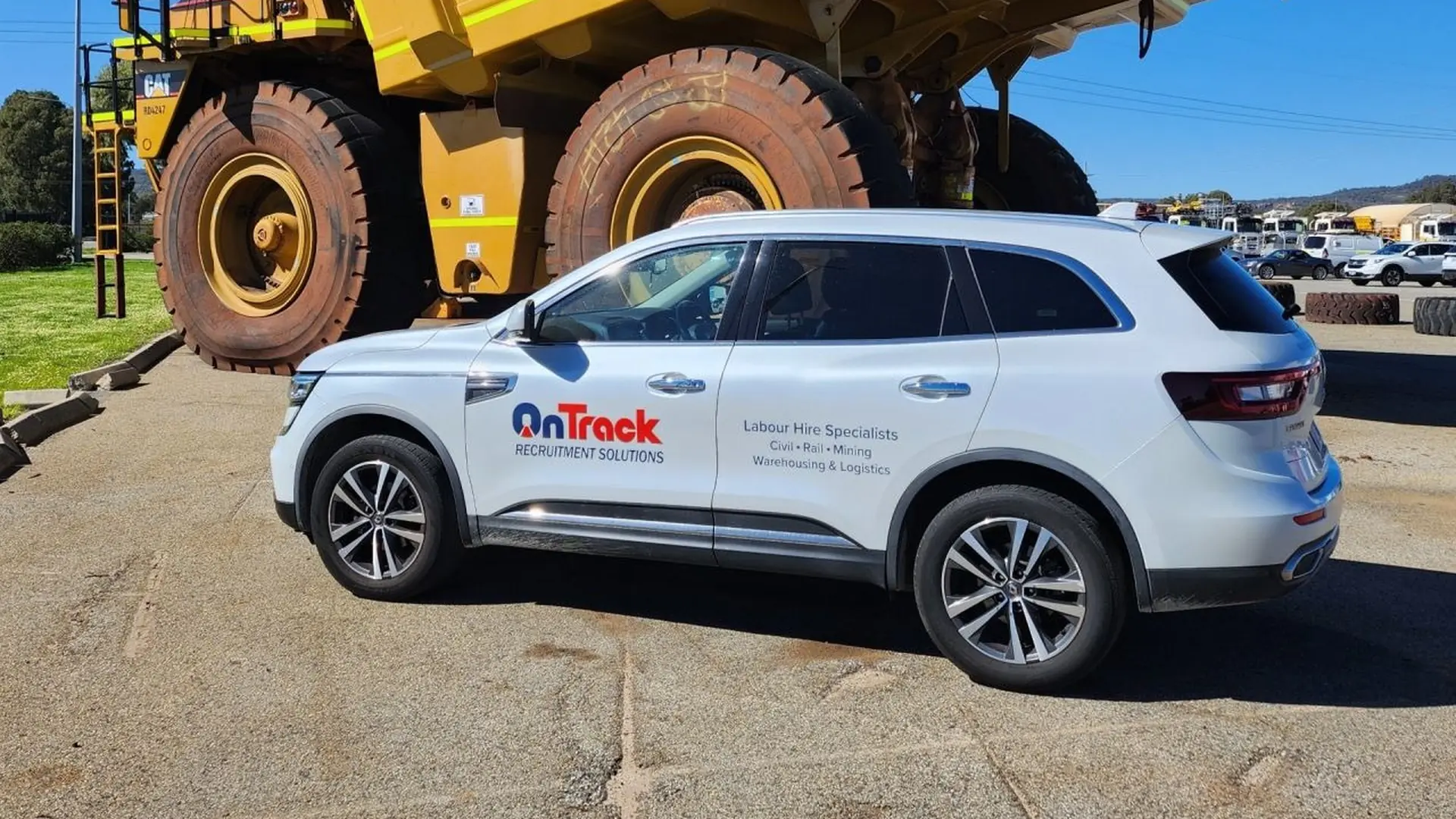 On Track vehicle parked beside a mining haul truck